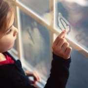 Little girl drawing on a streamed up bathroom window Little girl drawing on a streamed up window