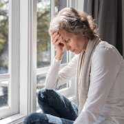 Depressed woman in from of windows