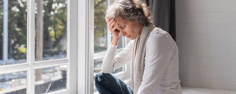 Depressed woman in from of windows
