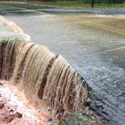 Flood waters washing away a road